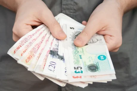 average UK salary concept - man counting pounds